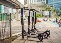 A group of scooters on a sidewalk Description automatically generated