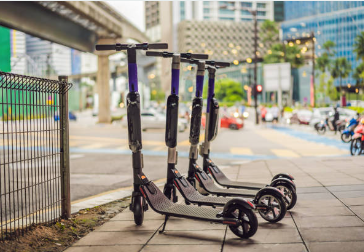 A group of scooters on a sidewalk Description automatically generated