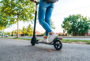 A person riding a scooter Description automatically generated